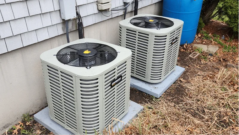 Central air conditioning condenser units installed outside a South Shore home
